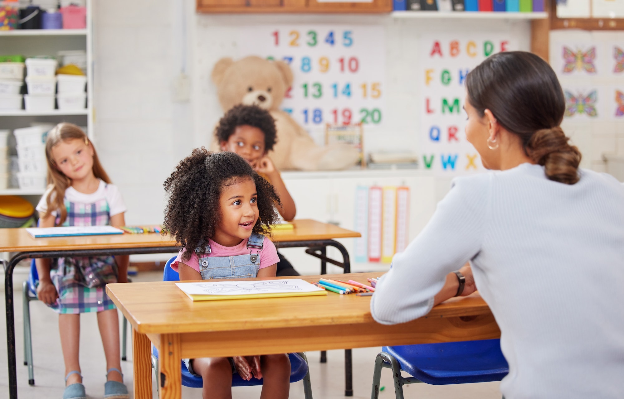 Shot of a young woman teaching a class of preschool children